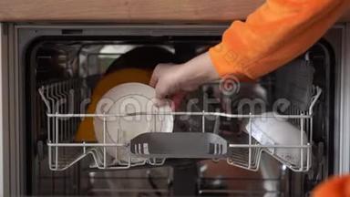 一个女人打开洗碗机，在里面放了一个脏盘子